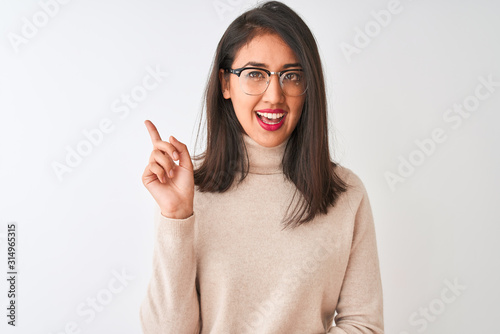 Chinese woman wearing turtleneck sweater and glasses over isolated white background very happy pointing with hand and finger to the side