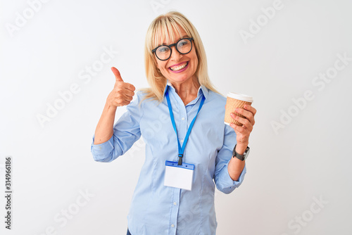 Businesswoman wearing glasses and id card drinking coffee over isolated white background happy with big smile doing ok sign  thumb up with fingers  excellent sign