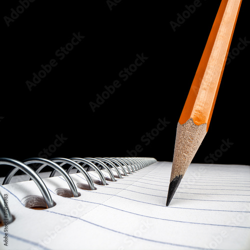 Tilted pencil isolated on white notebook
