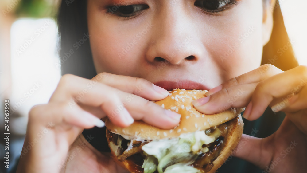 Hungry woman eating a BBQ hamburger with vegetable and grill pork, vintage picture style. Hungry woman eating a BBQ hamburger with vegetable and grill pork, vintage picture style.