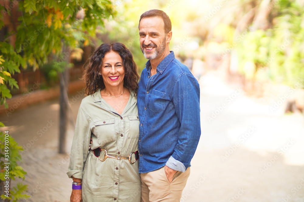 Middle age beautiful couple smiling happy and confident at town park. Standing with smile on face and hugging Middle age beautiful couple smiling happy and confident at town park. Standing with smile on face and hugging