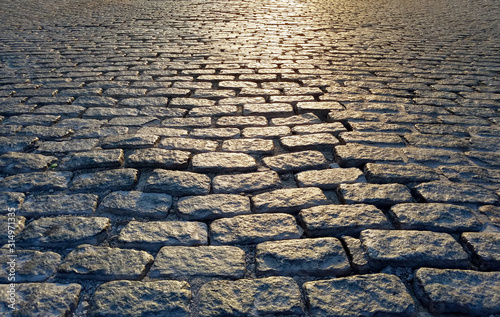 Принти на полотні Light shining on a cobblestone street background texture, New York City