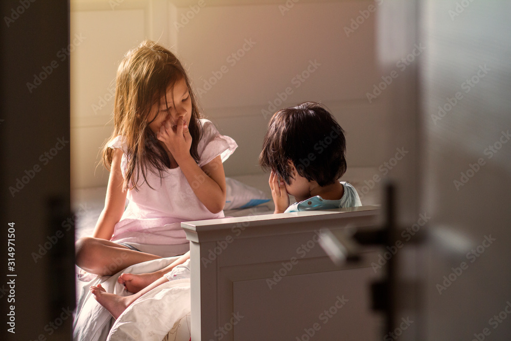 Soft focus image of Kids in their bedroom.The warm climate of Asian mixed race sibling wake up in the morning,spent their time together.Selective focus.Image with noise and grain.Warm climate concept.