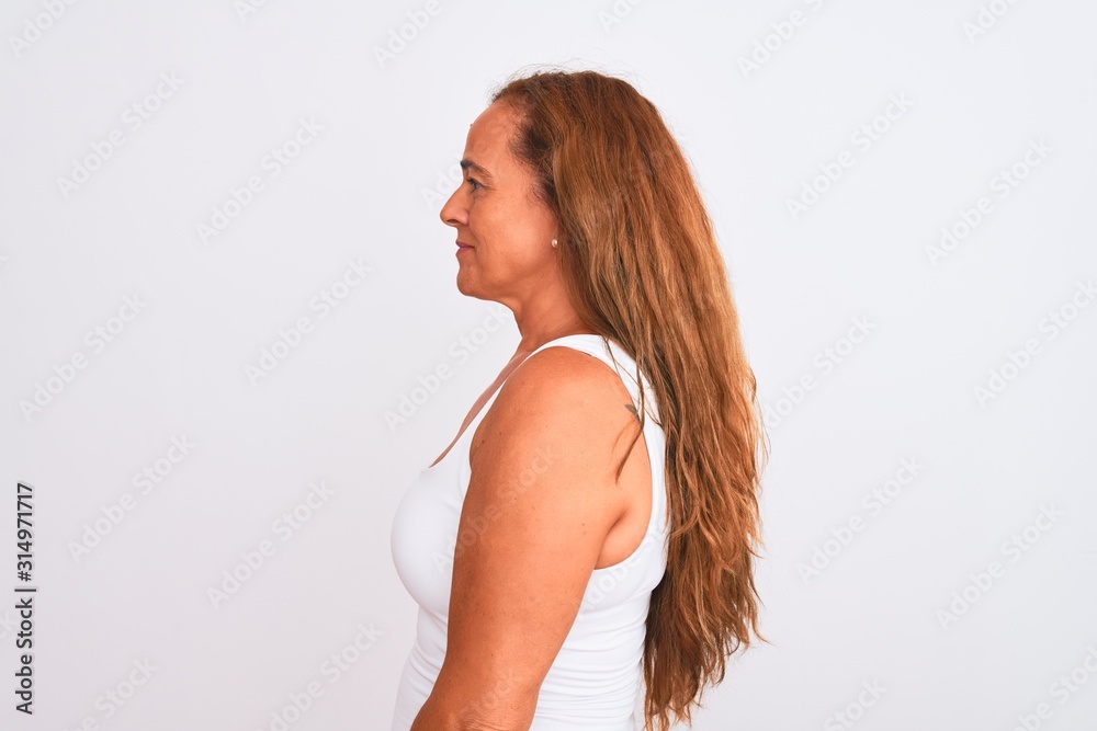 Naklejka premium Middle age mature woman standing over white isolated background looking to side, relax profile pose with natural face and confident smile.