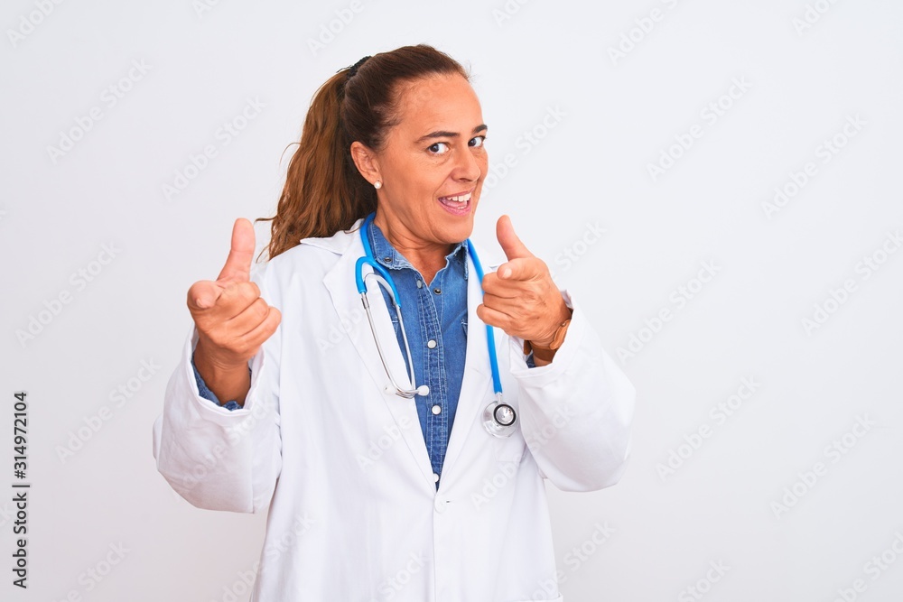 Middle age mature doctor woman wearing stethoscope over isolated background pointing fingers to camera with happy and funny face. Good energy and vibes. Middle age mature doctor woman wearing stethoscope over isolated background pointing fingers to camera with happy and funny face. Good energy and vibes.