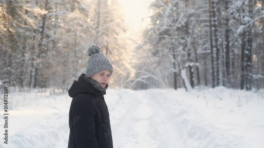 young man in warm winter clothes walks through winter snow forest. Beautiful nature in Park. Knitted hat and scarf for warm walks in nature. Snowdrifts and snowstorms in forest. clean air among trees. young man in warm winter clothes walks through winter snow forest. Beautiful nature in Park. Knitted hat and scarf for warm walks in nature. Snowdrifts and snowstorms in forest. clean air among trees.