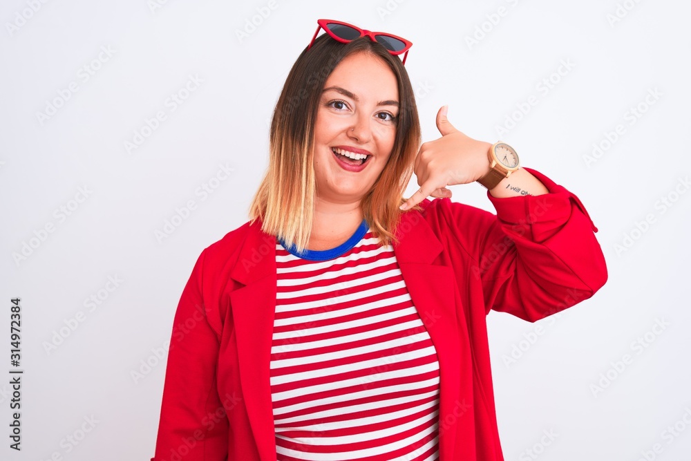 Young beautiful woman wearing striped t-shirt and jacket over isolated white background smiling doing phone gesture with hand and fingers like talking on the telephone. Communicating concepts. Young beautiful woman wearing striped t-shirt and jacket over isolated white background smiling doing phone gesture with hand and fingers like talking on the telephone. Communicating concepts.