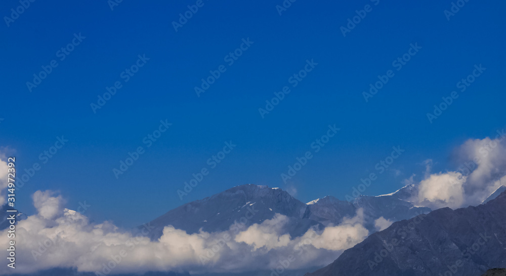 Snow-covered Mountain With Blue Sky, Cloud and Fog Snow-covered Mountain With Blue Sky, Cloud and Fog