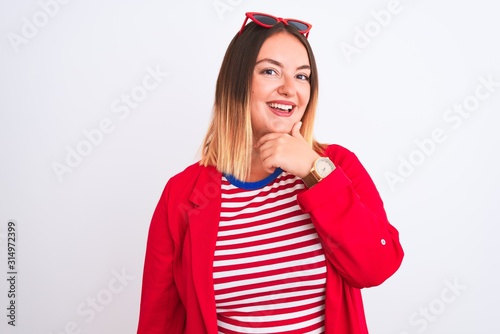 Young beautiful woman wearing striped t-shirt and jacket over isolated white background looking confident at the camera smiling with crossed arms and hand raised on chin. Thinking positive.