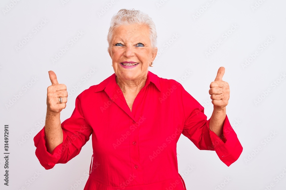 Senior grey-haired woman wearing red casual shirt standing over isolated white background success sign doing positive gesture with hand, thumbs up smiling and happy. Cheerful expression and winner Senior grey-haired woman wearing red casual shirt standing over isolated white background success sign doing positive gesture with hand, thumbs up smiling and happy. Cheerful expression and winner