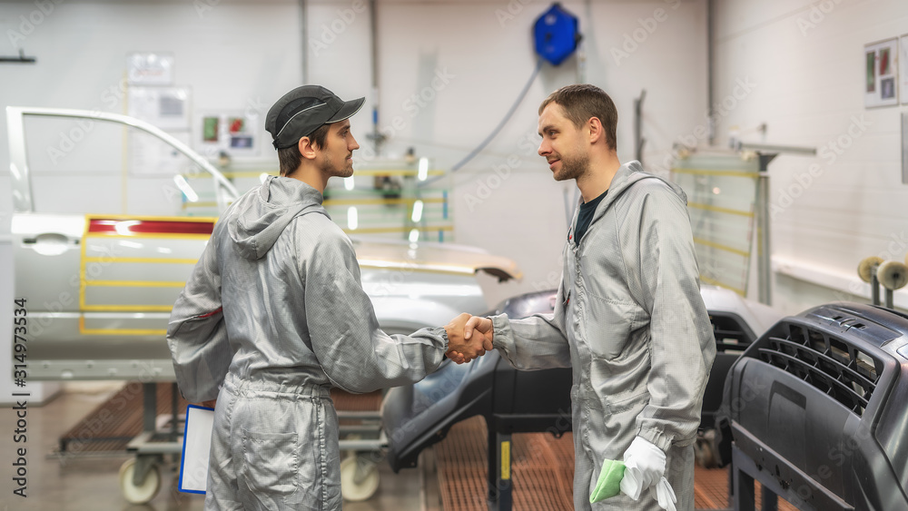 Friendly handshake of two employees of the paint shop. Friendly handshake of two employees of the paint shop.