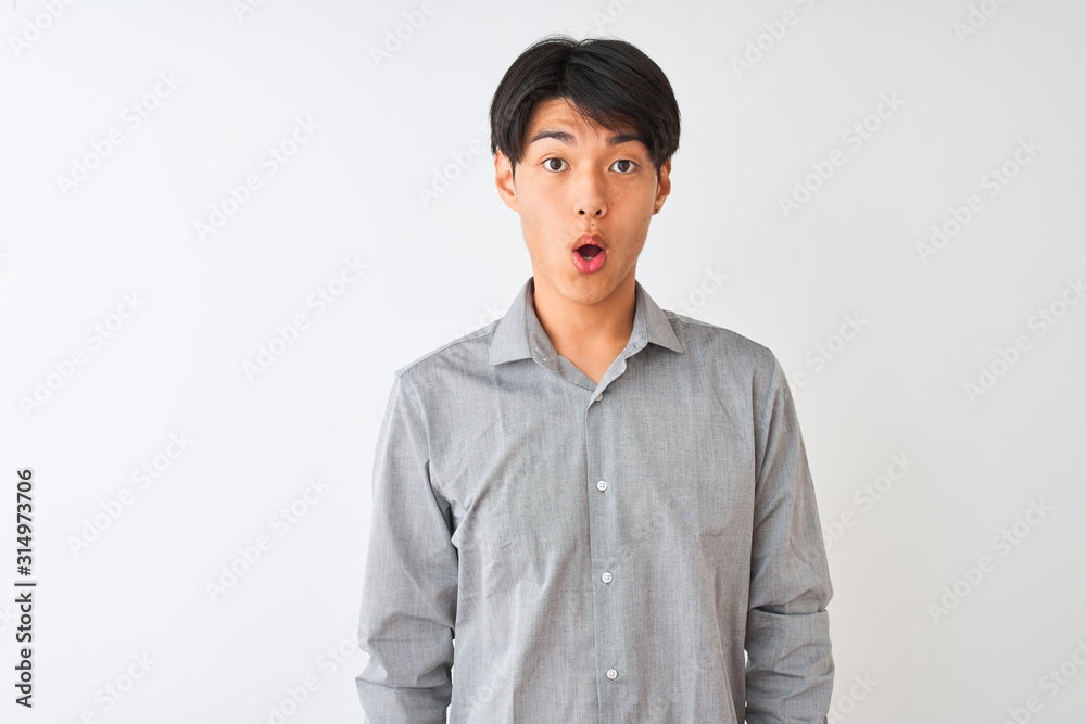 Chinese businessman wearing elegant shirt standing over isolated white background afraid and shocked with surprise expression, fear and excited face. Chinese businessman wearing elegant shirt standing over isolated white background afraid and shocked with surprise expression, fear and excited face.