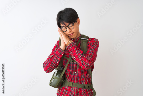 Chinese hiker man wearing backpack canteen glasses over isolated white background sleeping tired dreaming and posing with hands together while smiling with closed eyes.