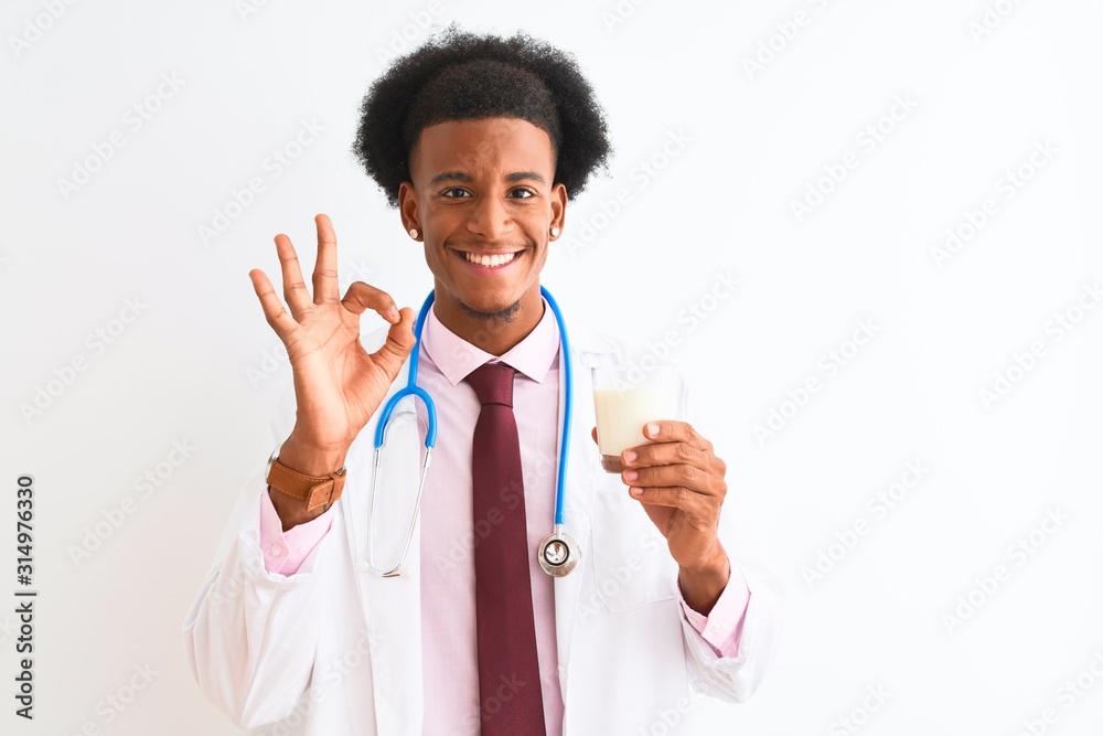 Young african american doctor man drinking glass of milk over isolated white background doing ok sign with fingers, excellent symbol Young african american doctor man drinking glass of milk over isolated white background doing ok sign with fingers, excellent symbol