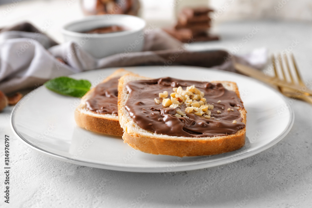 Plate with fresh bread and chocolate paste on table Plate with fresh bread and chocolate paste on table