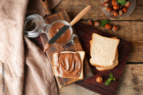 Fresh bread with tasty chocolate paste on table