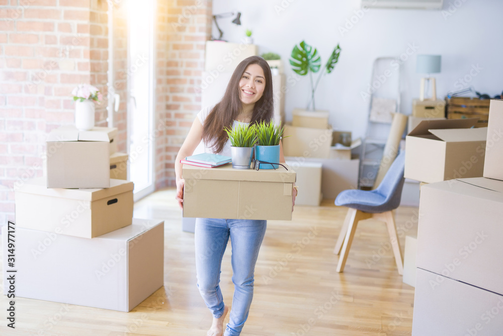 Young beautiful woman moving cardboard boxes at new home Young beautiful woman moving cardboard boxes at new home