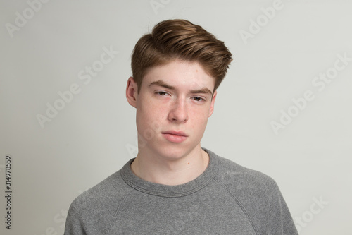 Tired young man wearing sweatshirt in studio
