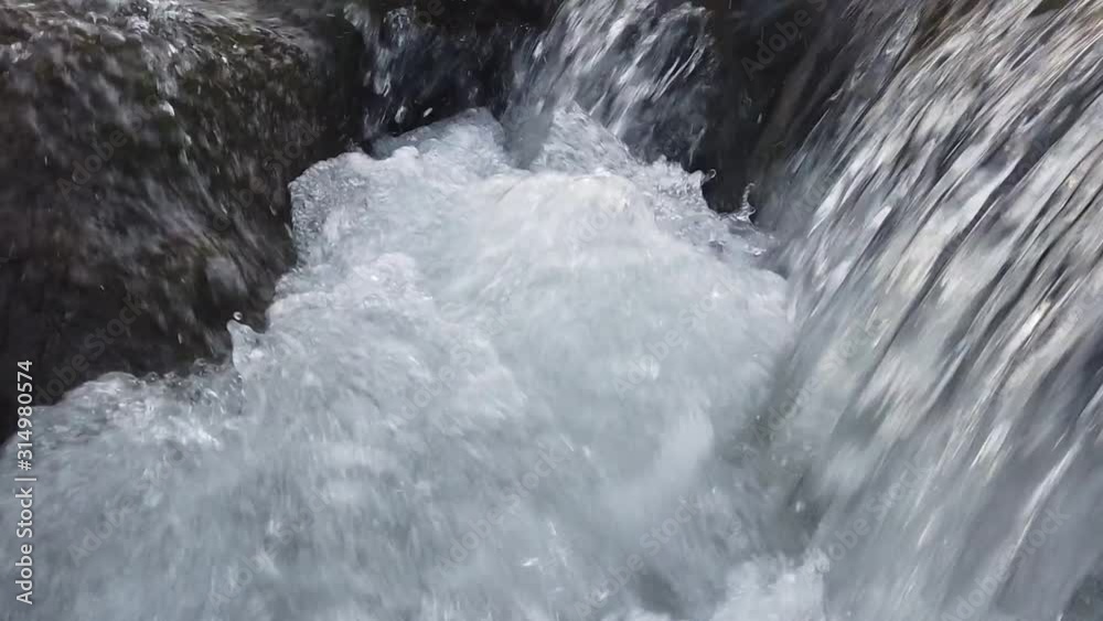 Waterfall in the winter season, forming ice and bubble in blue and cold tones. Waterfall in the winter season, forming ice and bubble in blue and cold tones.