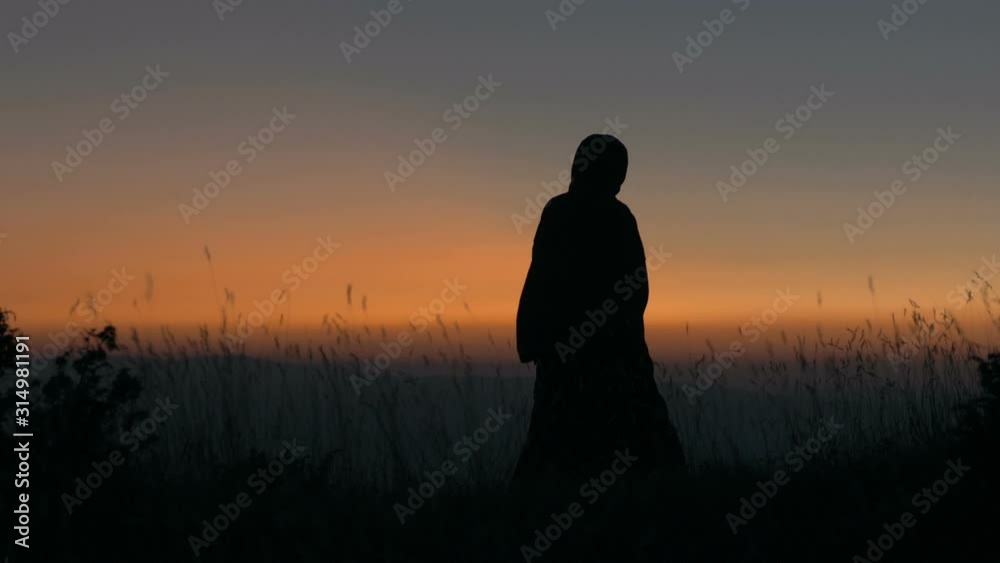 Medieval druid standing on mountain top Medieval druid standing on mountain top