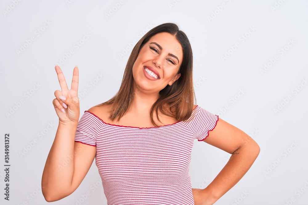 Portrait of beautiful young woman standing over isolated white background smiling with happy face winking at the camera doing victory sign. Number two. Portrait of beautiful young woman standing over isolated white background smiling with happy face winking at the camera doing victory sign. Number two.