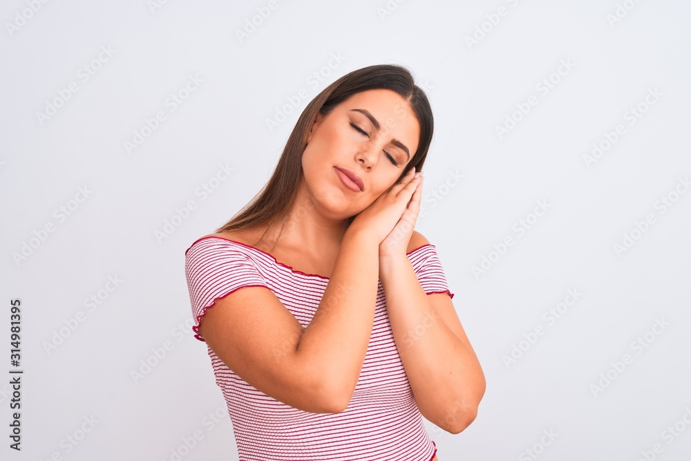 Portrait of beautiful young woman standing over isolated white background sleeping tired dreaming and posing with hands together while smiling with closed eyes. Portrait of beautiful young woman standing over isolated white background sleeping tired dreaming and posing with hands together while smiling with closed eyes.