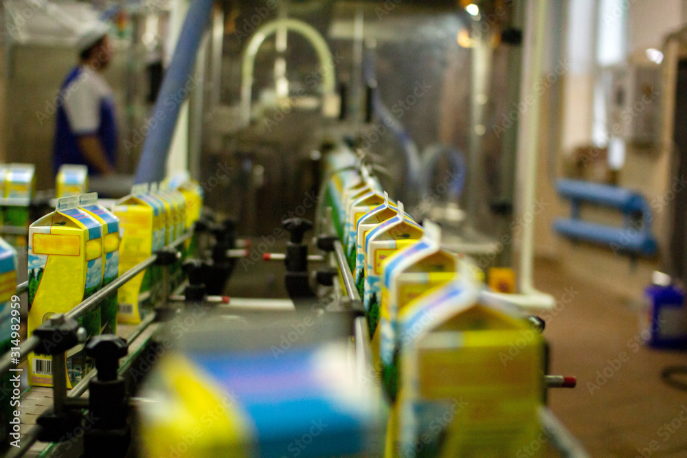 Dairy products on the factory milk packaging line. Dairy products in the package are moved on a conveyor belt . Dairy products on the factory milk packaging line. Dairy products in the package are moved on a conveyor belt .