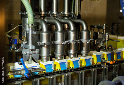 Dairy products on the factory milk packaging line. Dairy products in the package are moved on a conveyor belt .