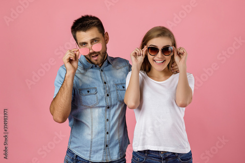 beautiful couple in love have fun on st valentines day. man and woman in sunglasses on pink background © producer