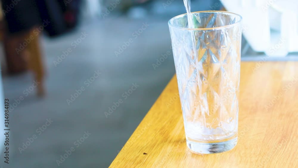 Filling a glass of water in the kitchen with natural light