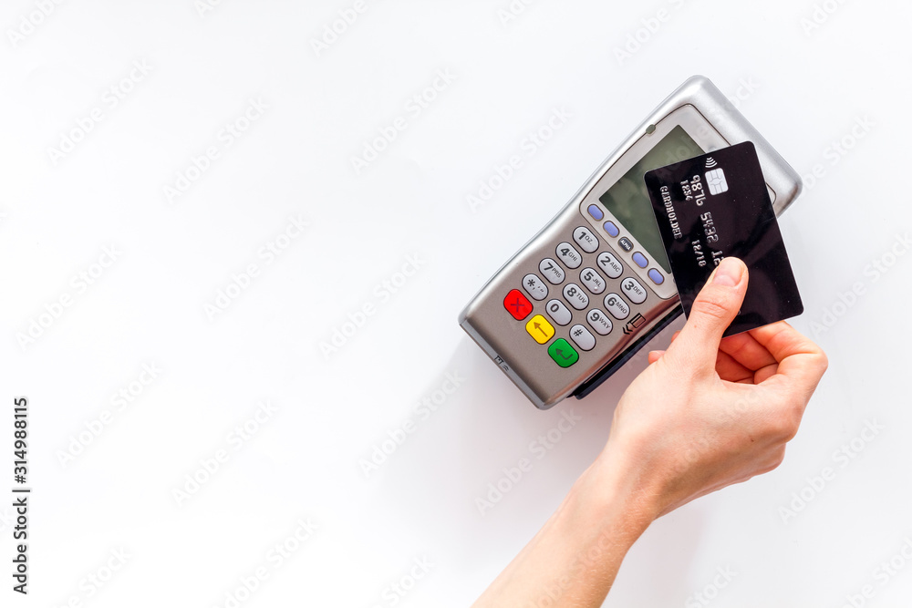 Contactless payment, paypass. Hand hold bank card near terminal on white background top-down copy space Contactless payment, paypass. Hand hold bank card near terminal on white background top-down copy space