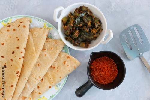 Fresh Indian flat bread chapati or Roti along with Okra fry and spicy red peanut garlic chutney