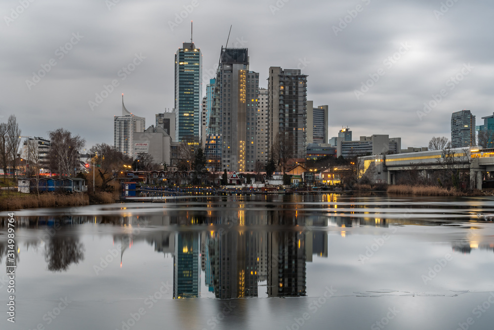 Naklejka premium Widok na budynki i wieżowce Wiednia z brzegów Dunaju w rejonie Alte Donau 
