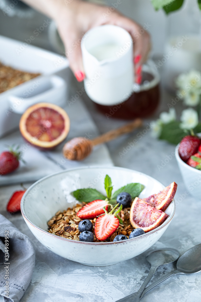 Healthy breakfast with granola, yogurt, fruits, berries on a white plate in white plate. Selective focus. Healthy breakfast with granola, yogurt, fruits, berries on a white plate in white plate. Selective focus.