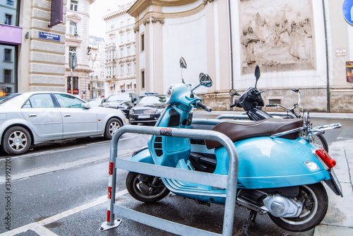Photography blue scooter moped parked at city street side