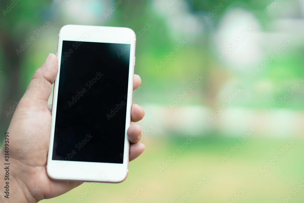 Holding and use smart mobile phone to communication at outdoor in park. Holding and use smart mobile phone to communication at outdoor in park.
