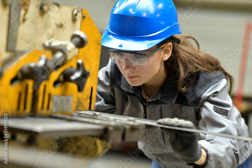 Young apprentice using steelworks machine