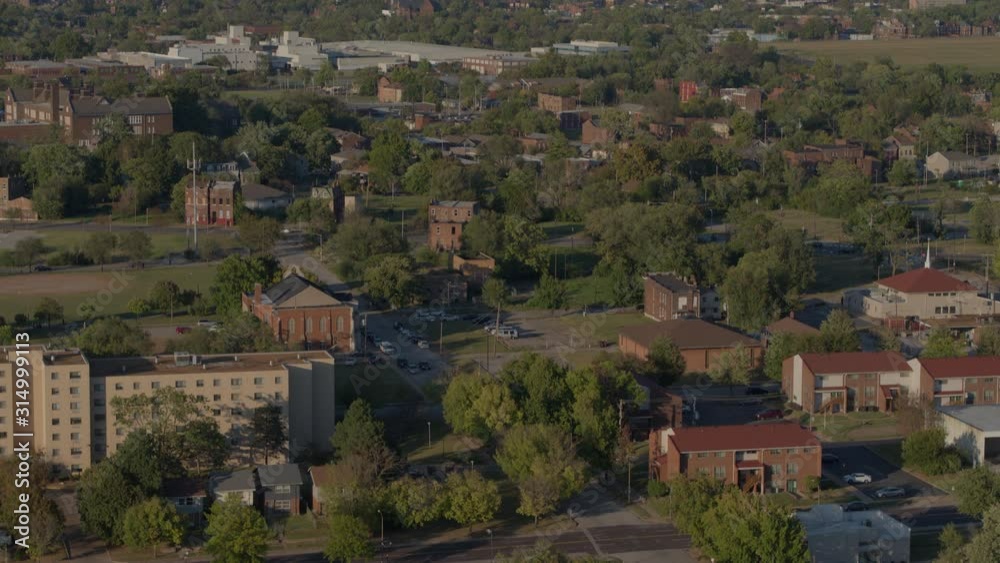 Aerial view of north St. Louis tilt down to storefronts and parked car in parking lot Aerial view of north St. Louis tilt down to storefronts and parked car in parking lot