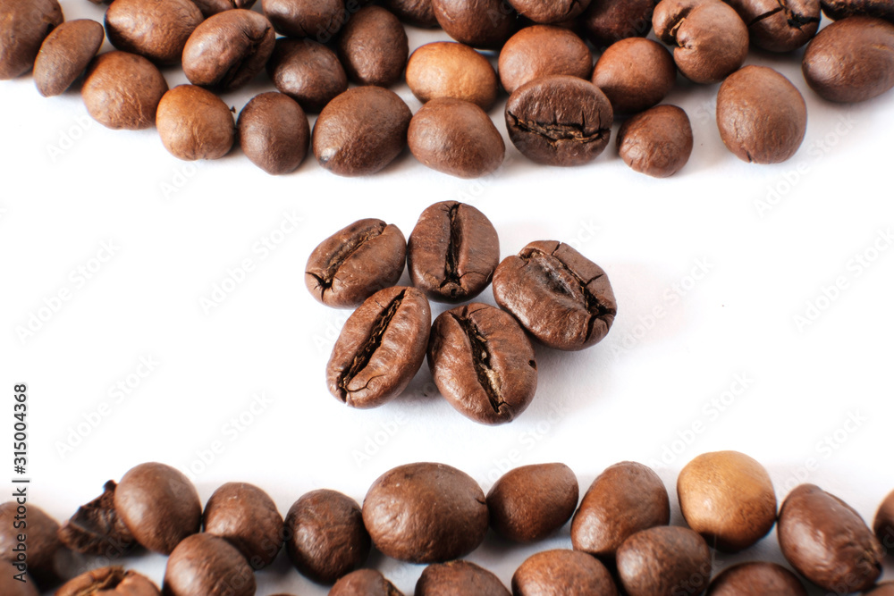 Coffee beans lie on a white sheet of paper Coffee beans lie on a white sheet of paper