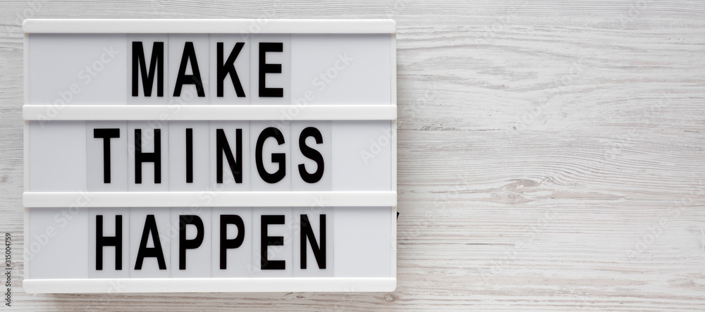 'Make things happen' words on a lightbox on a white wooden surface, top view. Overhead, from above, flat lay. Space for text. 'Make things happen' words on a lightbox on a white wooden surface, top view. Overhead, from above, flat lay. Space for text.