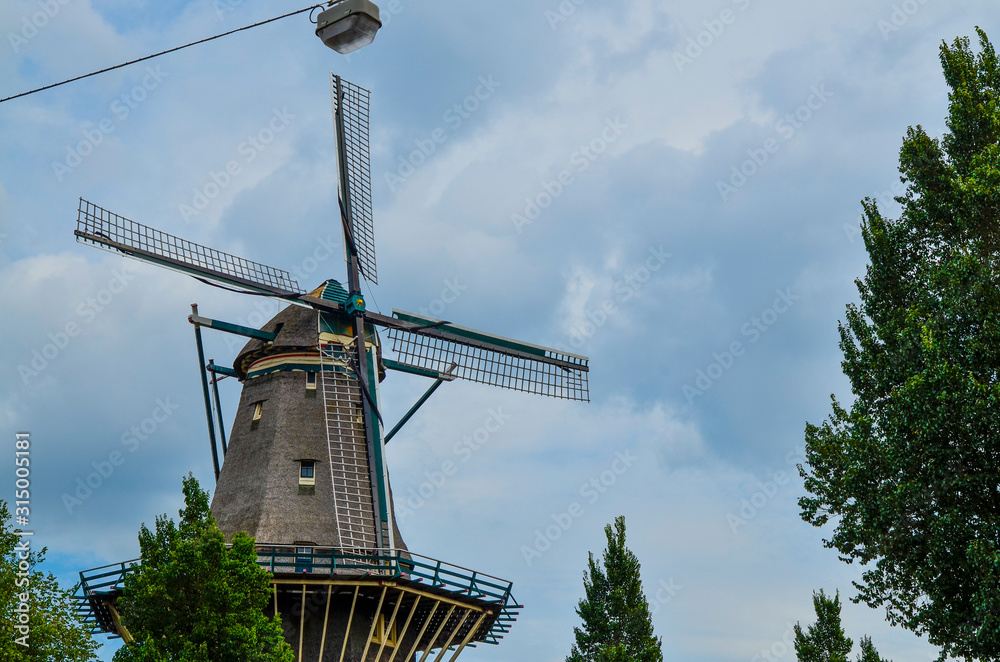 Amsterdam, Holland, August 2019.The De Gooyer Mill is located on the edge of the historic center:it is used as a brewery.Perfectly intact it is a dip in the past in the city.Blue sky with white clouds
