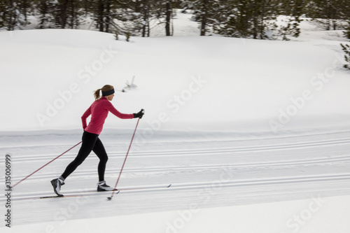 Cross-country skiing: young woman cross-country skiing on a winter day (motion blurred image) photo