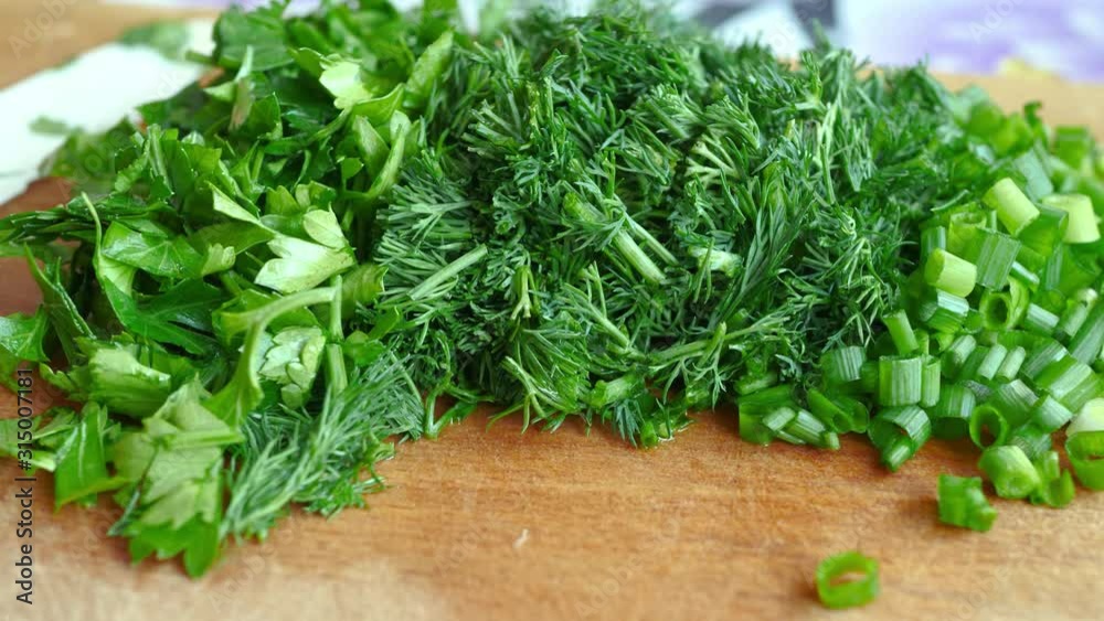 Knife, Cut Green Onion, Parsley, Dill On Brown Wooden Chopping Board. Veganism Concept Knife, Cut Green Onion, Parsley, Dill On Brown Wooden Chopping Board. Veganism Concept