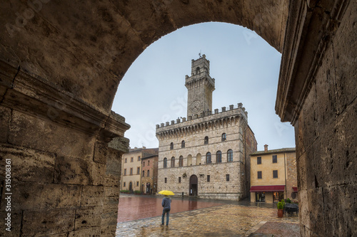 Bilde på lerret Tourist with yellow umbrella walks through empty medieval Grande Square - main s