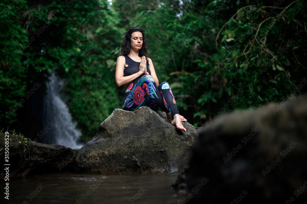 Yoga practice and meditation in nature. Woman practicing near river Yoga practice and meditation in nature. Woman practicing near river