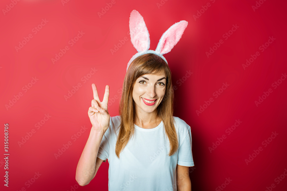 Young girl with rabbit ears on a pink background. Happy Easter Concept, Easter Bunny
