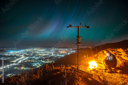 Bonfire on the background of the starry sky and night city