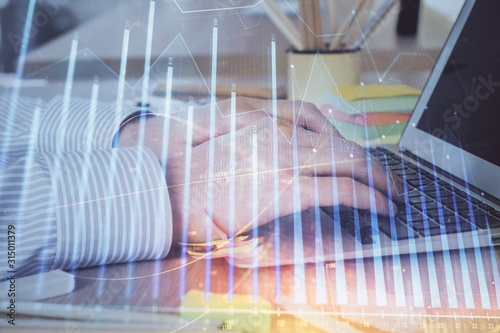 Multi exposure of stock market graph with man working on laptop on background. Concept of financial analysis.