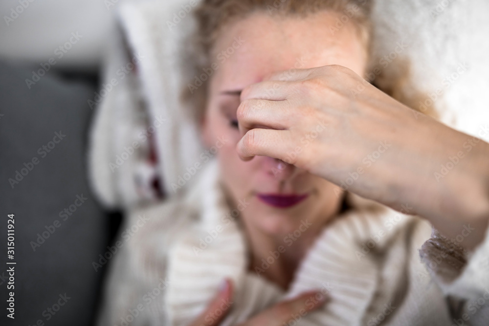 Woman with sinuses problem, stomach, chest and head issues at home on a couch, being sick. Woman with sinuses problem, stomach, chest and head issues at home on a couch, being sick.