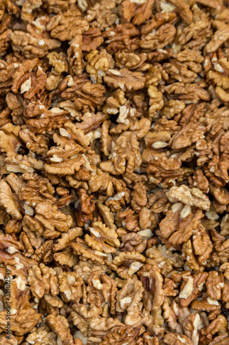 Closeup of big shelled walnuts pile. Selective focus.